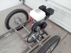 a small motorized vehicle parked in front of a garage door with two tires on the ground