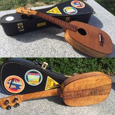 a ukulele sitting on the ground next to another ukulele with stickers