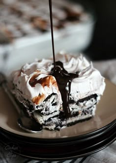 a piece of ice cream cake with chocolate sauce drizzled over it on a plate