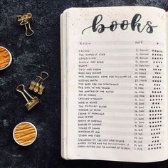 an open book sitting on top of a table next to some paper clips and scissors