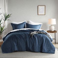 a bed with blue and white linens in a bedroom