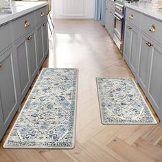 two rugs in the middle of a kitchen with blue cabinets and white appliances on either side