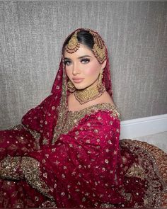 a woman wearing a red and gold bridal gown