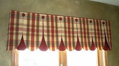 a window with red and green checkered valance hanging from it's side