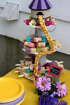 a table topped with lots of food next to a yellow plate and purple umbrella on top of it