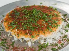 a plate with rice and seasoning on it, ready to be eaten or served