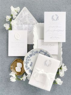 the wedding stationery is laid out on top of plates and napkins with flowers