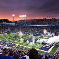 a football stadium filled with lots of people watching fireworks go off in the air and on the field