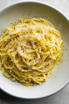 a white bowl filled with pasta and parmesan cheese