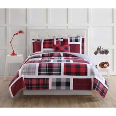 a red and black plaid comforter set on a bed with white headboard, nightstands and lamp