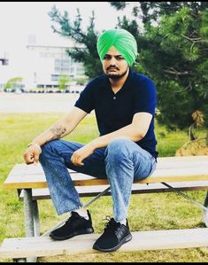 a man with a green turban sitting on a bench