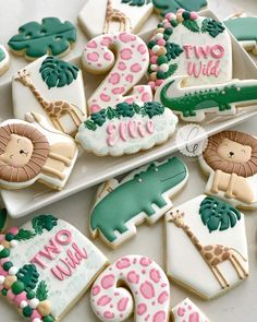 decorated cookies with animals, lions and giraffes are arranged on a plate