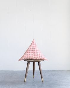 a red and white checkered chair sitting on top of a cement floor