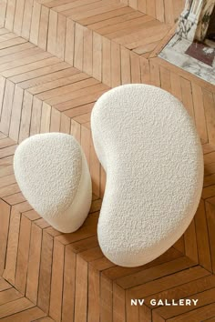 two white shoes are sitting on the floor next to each other and one is made out of foam