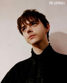 a young man wearing a black shirt looking up