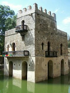 an old brick building sitting next to a body of water