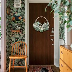 a wooden chair sitting in front of a door next to a rug on the floor