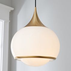 a light fixture hanging from the ceiling in a room with white walls and window sill