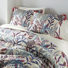 an image of a bed with pillows and comforter set on it's headboard