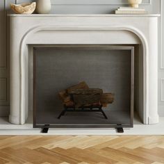 a fireplace with a white mantle and wood logs