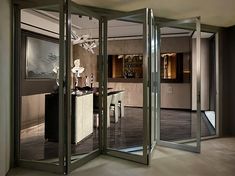 an open room with mirrored doors and chandelier in the center, leading to a dining area