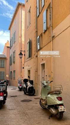 several scooters are parked on the street in front of an old building with shuttered windows