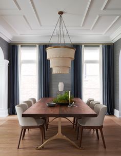 a dining room table with chairs and a chandelier hanging from the ceiling