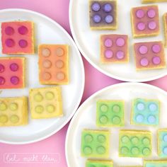 two white plates topped with different colored desserts on top of a pink tablecloth