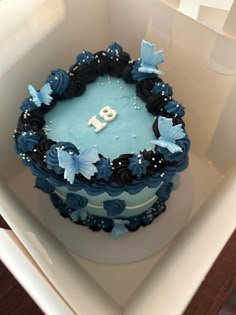 a blue and black cake with flowers on it