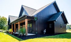 a house with black shingles and green grass