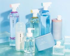 several different types of hand sanitizers and soaps on a blue table top