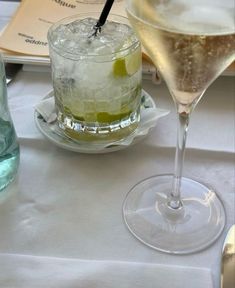 two glasses filled with drinks sitting on top of a table