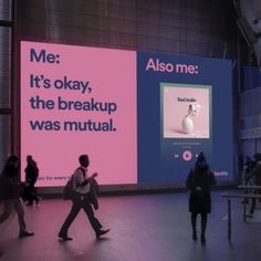 people are walking around in front of large billboards that read me it's okay, the breakup was mutilal