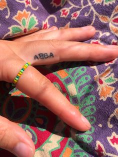 a woman's hand with the word abra tattooed on her left ring finger