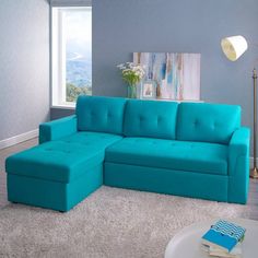 a living room with a blue couch and ottoman