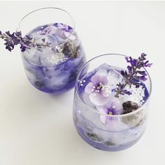 two glasses filled with ice and purple flowers