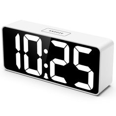 the alarm clock is white and black with numbers on each side that read 3 30