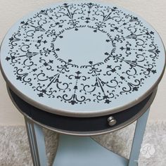 a round table with black and white designs on the top, sitting on carpeted floor