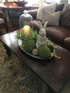 a living room with a couch, coffee table and bunny figurine on it