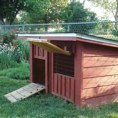 a dog house in the grass with a ramp leading up to it's door