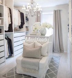 a bedroom with white furniture and chandelier hanging from the ceiling in front of a window