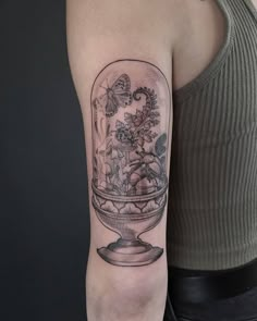 a woman's arm with a snow globe tattoo on it