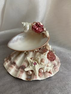 a seashell with pearls and a pink bead on it