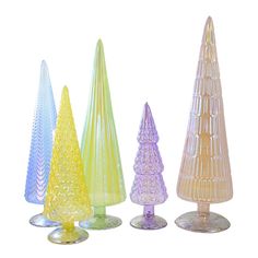 four different colored glass trees are on display