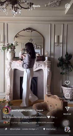 a woman standing in front of a fire place