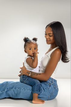 a woman sitting on the ground holding a small child