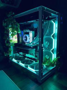 a computer case sitting on top of a wooden floor next to a plant in the dark