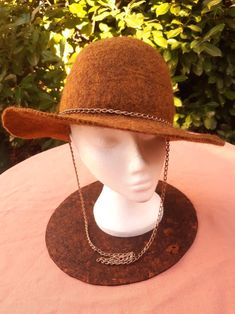 Brown felted wool hat with gold style chain. Handmade by Estambul Atelier. Materials: 100% natural and organic Merino wool. Adult - one size. **Made to Order** There may be a slight design/ colour variance compared to the images as each piece is hand made to order. Made with the wet felting technique using warm water and pure olive oil soap to blend the natural fibres into a strong and breathable fabric. I recommend hand washing, but can be machine washed using the wool/ delicate setting at a co Olive Oil Soap, Natural Fibres, Wet Felting, Felted Wool, Wool Hat, Gold Style, Natural Fibers, Wool Felt, Breathable Fabric