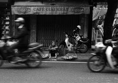 black and white photograph of people on motorcycles in front of a cafe with dogs sitting outside