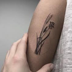 a woman's arm with a flower tattoo on the left side of her arm